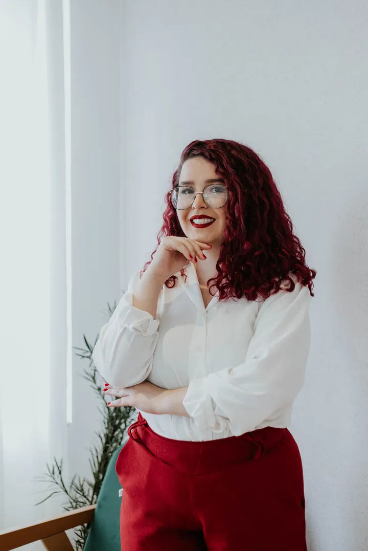 Rhavena Magna, Doula em Goiânia, sorrindo encostada numa parede clara